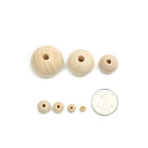 Natural round wooden beads in various sizes with center holes and a 1-yuan coin scale