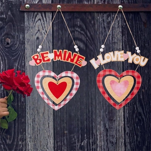 Dettaglio di cuori pendenti in legno con scritte Be Mine e I Love You per San Valentino