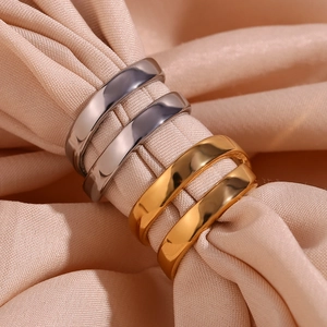 Macro shot of minimalist gold and silver polished metal rings on pink silk fabric