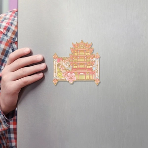 Detail of a metal Yellow Crane Tower souvenir fridge magnet on a brushed steel door