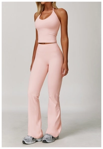 Ensemble haut de yoga licou rose et legging évasé porté par un mannequin en studio