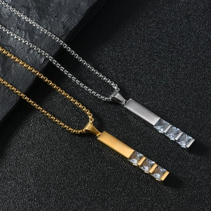 Detail of gold and silver box chains featuring vertical pendants with four square zircons