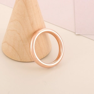 Dettaglio di un anello in titanio oro rosa 4mm su un espositore a cono in legno