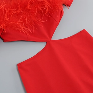 Detail of red off-shoulder dress featuring cutout waist and matching feather trim accents