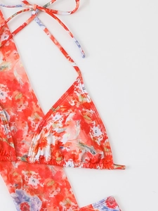Detail of floral bikini top with ruffled texture and vibrant orange blue patterns