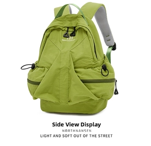 Detail of green nylon backpack with breathable mesh straps and multiple storage pockets