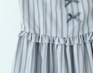 Detailed macro shot of blue striped dress fabric with small dark grey ribbon bows