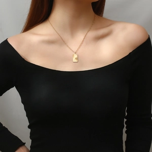 Golden rectangular necklace with sunburst texture shown on a model neck