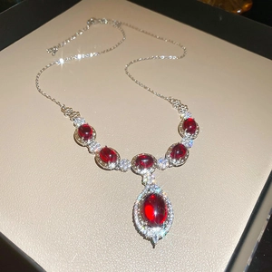 Detail of elegant teardrop necklace with ruby stones and diamonds in a jewelry box