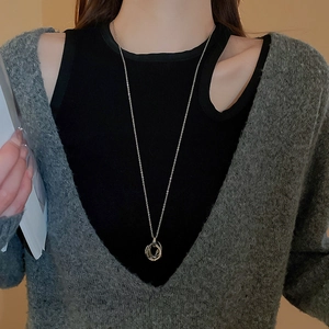 Lifestyle shot of model wearing a layered interlocking multi-ring zircon pendant necklace