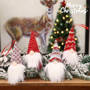 Set of 4 knitted Christmas gnomes in red, white and grey hanging on snowy pine branches