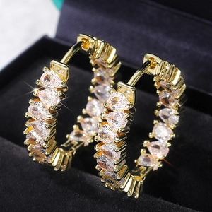 Luxury gold hoop earrings with row of pear-cut AAA cubic zirconia on black velvet background
