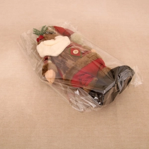 Detailed view of plush Santa Claus figure inside transparent packaging for protection