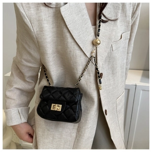 Detail of black quilted leather mini bag with gold chain strap and spherical buckle adjuster