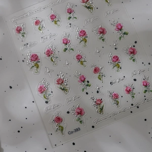 Macro detail of 3D embossed rose nail stickers with silver foil accents and floral text