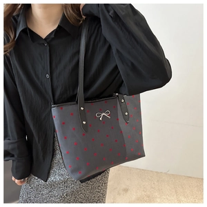 Detailaufnahme der grauen Polka-Dot-Einkaufstasche mit rotem Muster und Silberschleife