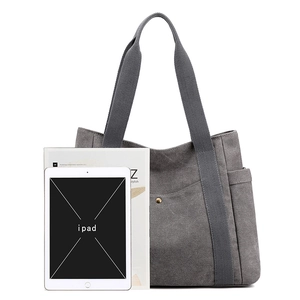Large gray canvas tote bag with side pocket shown next to an iPad for size comparison