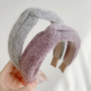 Close-up of thick knitted winter headband with cross-knot design and fuzzy texture
