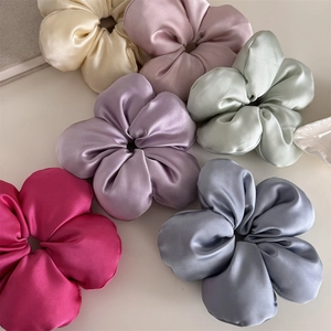 Detailed view of six assorted satin flower hair scrunchies in pastel elegant colors