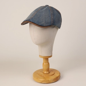Classic navy denim ivy cap with brown leather trim and contrast stitching on a mannequin