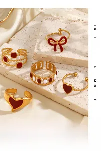Close-up of vintage gold rings set featuring red heart and bow enamel details