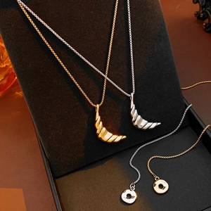 Detailed view of gold and silver textured crescent moon pendants on display stands