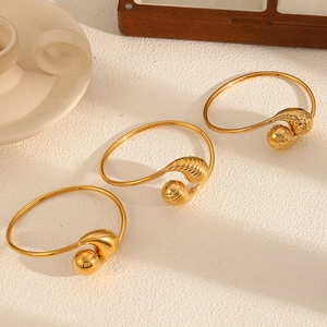 Three-piece gold hollow teardrop bangles in mirror, striped, and hammered finishes
