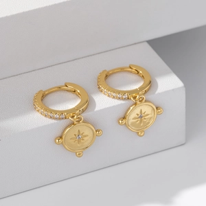 Close-up of gold plated S925 silver starburst hoop earrings with sparkling zircon inlay