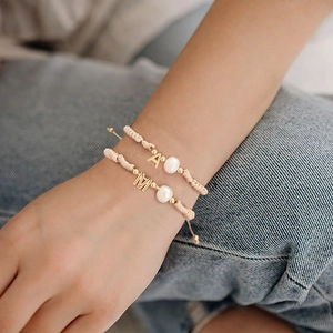 Handmade woven pearl bracelet set with adjustable cord and gold letter A and M charms