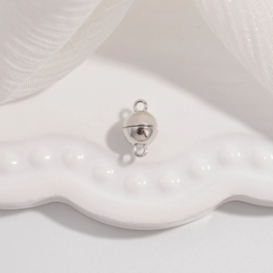 Detailed view of S925 sterling silver spherical magnetic clasp on a white tray