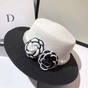 Close-up of elegant boater hat with pearl trim and fabric camellia flower details