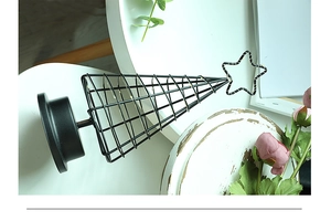 Macro detail of Nordic black metal cone LED Christmas tree lamp with star topper