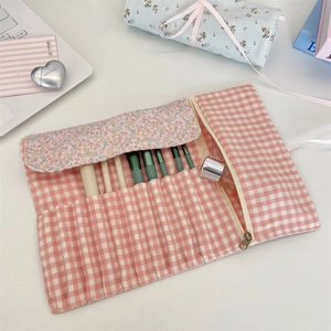 Detail view of floral makeup brush roll organizer with slots and a zipper pocket