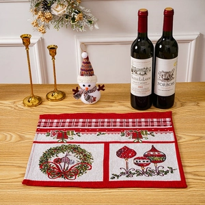 Detailed close-up of woven Christmas placemat with red festive floral and bow patterns