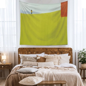 Abstract landscape wall tapestry displayed above a cozy bed in a modern bedroom