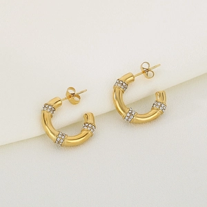 Détail macro de boucles d'oreilles bambou en or 18K avec cristaux de strass brillants