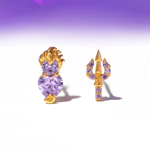 Detail of asymmetric gold earrings with lavender zircon heart and trident designs