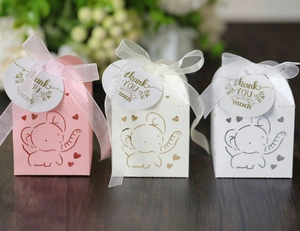 Detail of laser-cut elephant candy boxes in pink and white with ribbons and thank you tags