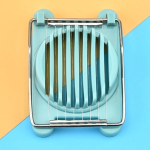 Close-up of a blue manual egg slicer with stainless steel wires on a dual-color background