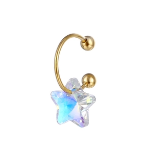 Close-up of golden C-shaped piercing jewelry with iridescent crystal star pendant