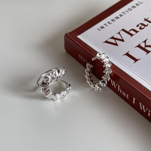 Minimalist 925 sterling silver U-shaped earrings with irregular lava texture on red book