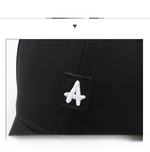 Detailed close-up of white letter A embroidery on a black cotton canvas baseball cap