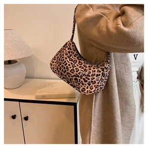 Gros plan d'un sac à bandoulière léopard porté par un mannequin en intérieur