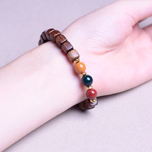 Macro detail of sandalwood square beads and colorful spacer beads on a wrist