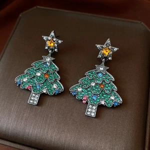 Detail of Christmas tree earrings with sparkling colorful rhinestones and gold star top