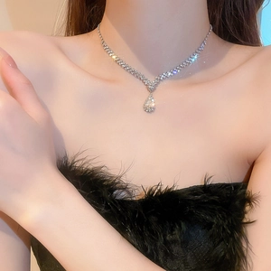 Gros plan d'un ensemble collier et boucles d'oreilles en strass porté par un mannequin