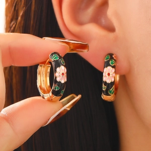 Retro Chinese style flower enamel hoop earrings in gold finish showing worn effect