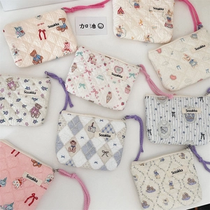 Close-up of floral quilted pouches with soft texture, woven labels, and zipper details