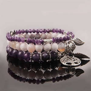 Detail of tree of life and leaf charms on bohemian purple gemstone beaded bracelets