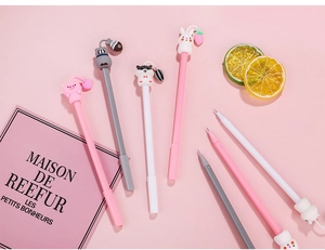 Close-up of cute cartoon animal silicone pen toppers in pink and white school supplies
